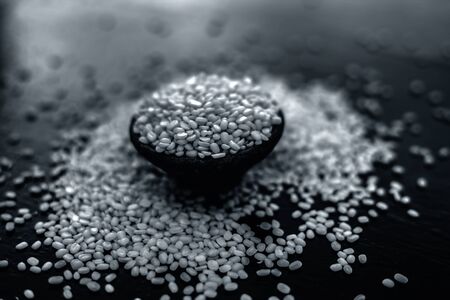 Unskinned split mung dal or moong dal in a black colored clay bowl on the black wooden surface used for various dishes. Also referred to as green gram, maash, or moong or unskinned mung bean.の写真素材