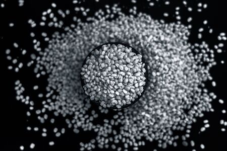 Unskinned split mung dal or moong dal in a black colored clay bowl on the black wooden surface used for various dishes. Also referred to as green gram, maash, or moong or unskinned mung beam.の写真素材