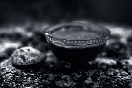 Neem or Indian Lilac face mask on the black wooden surface for acne and scars consisting of gram flour, neem paste, and some curd.の写真素材