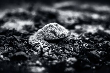 Neem or Indian Lilac face mask on the black wooden surface for acne and scars consisting of gram flour, neem paste, and some curd.の写真素材