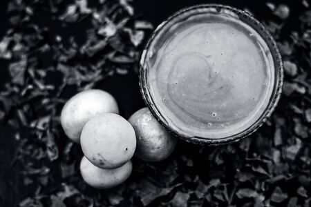 Neem or Indian Lilac face mask on the black wooden surface for oily skin consisting of neem leaves paste and lemon juice well mixed with rose water.の写真素材