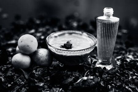 Neem or Indian Lilac face mask on the black wooden surface for oily skin consisting of neem leaves paste and lemon juice well mixed with rose water.の写真素材