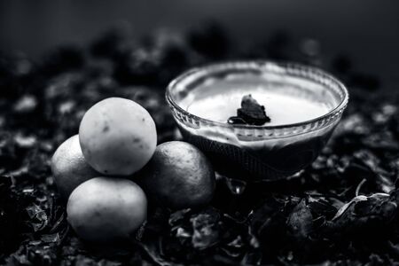 Neem or Indian Lilac face mask on the black wooden surface for oily skin consisting of neem leaves paste and lemon juice well mixed with rose water.の写真素材