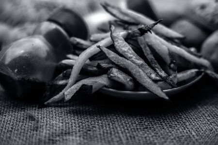 Fresh fired French fries of along with sprinkler of black pepper and salt on jute bag's surface and some raw potato also.の写真素材