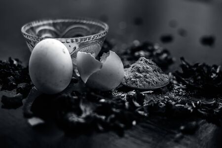 Egg and besan or chickpea flour or gram flour on wooden surface in a glass bowl along with raw egg and flour on the surface.For the treatment of lines and wrinkles.の写真素材