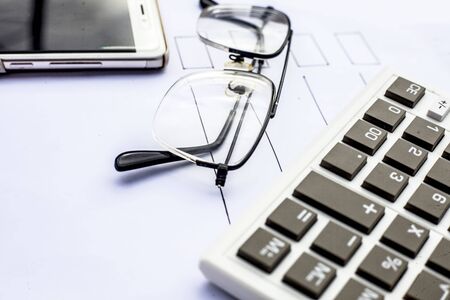 Close up of workplace of businessman or finance consultant isolated on white using credit card, cell phone, pen and calculator like things and some coins also.の写真素材