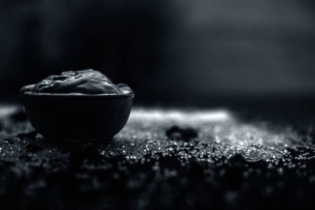 Ubtan/face mask/face pack of Multani mitti or fuller's earth on wooden surface in a glass bowl consisting of Multani mitti and coconut oil for the remedy or treatment of suntan.On the wooden surface.の写真素材