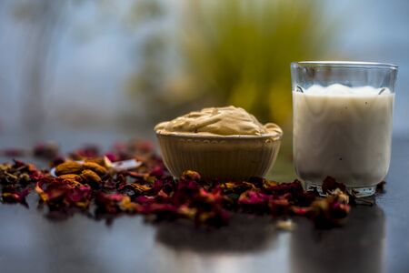 Multani mitti or fuller's earth or mulpani mitti face mask on wooden surface in glass bowl consisting of milk, almonds, and bentonite clay.For the treatment of softer skin.の写真素材
