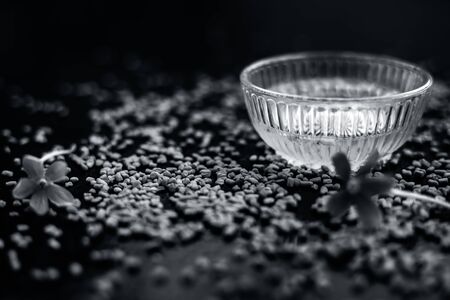 Famous natural method for dandruff on wooden surface in a glass bowl consisting of fenugreek seeds powder well mixed with lemon juice.With raw lemons and fenugreek seeds on the present on the surface.の写真素材