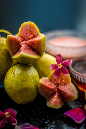 The easiest method to cure acne and scars with guava face mask consisting of guava pulp, honey, and some lemon juice.With ingredients on wooden surface in a glass bowl.の写真素材