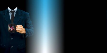 The young unidentifiable gentleman holding a black colored coffee mug in his hand. Concept of Corporate lifestyle against blue and white mixed colors background.の写真素材