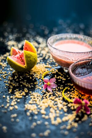 Guava face mask for dry skin on a wooden surface with vivid colors i.e., guava pulp, egg yolk, oatmeal, and some raw organic honey well mixed in a glass bowl along with raw ones.の写真素材