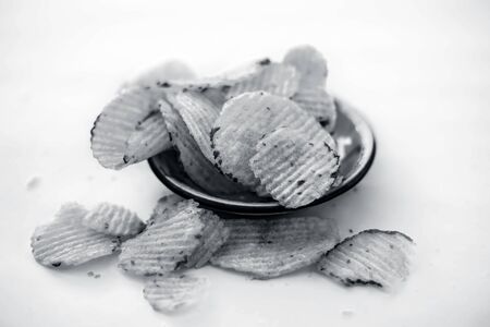 Organic processed potato chips in a glass plate isolated on white.の写真素材