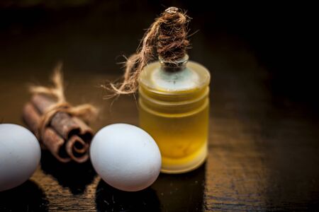 DIY hair mask of cinnamon, egg and olive oil on a wooden surface.Shot of oilve oil, egg and cinnamon sticks. Horizontal shot.の写真素材