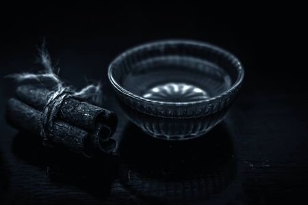 Cinnamon and honey hair mask in a glass bowl on a wooden surface with gold lights isolated. Along with raw cinnamon stick and honey present on the surface.の写真素材