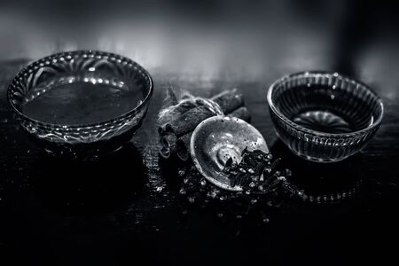 Cinnamon, honey & clove hair mask in a glass bowl on a wooden surface with gold lights isolated. Along with the raw cinnamon stick, honey, laung present on the surface.の写真素材