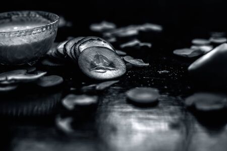 Carrot face mask on a black wooden surface consisting of some freshly squeezed carrot juice, cucumber paste and sour cream well mixed in a glass bowl for the treatment for acne and even skin tone.の写真素材