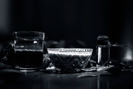 Hair remedy of all-purpose ayurvedic medicinal herb i.e. Neem or Nim or Indian lilac in a glass bowl along with neem leaves, freshwater & tea tree oil for dandruff or hair skin itching problems.の写真素材