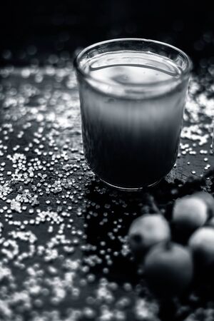 Best drink remedy to control weight on the black glossy wooden surface consisting of Banyan Tree fruit juice well mixed with milk and some sugar. Shot of all ingredients on surface.Vertical shot.の写真素材