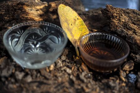 Home remedy for sexually transmitted diseases on a black glossy surface consisting of Banyan tree bark powder well mixed with water and some honey. Horizontal high angle shot.の写真素材