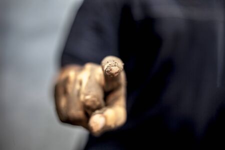 Dirty hand of farmer wearing t-shirt with mud under his nails and touching something virtual.Concept...