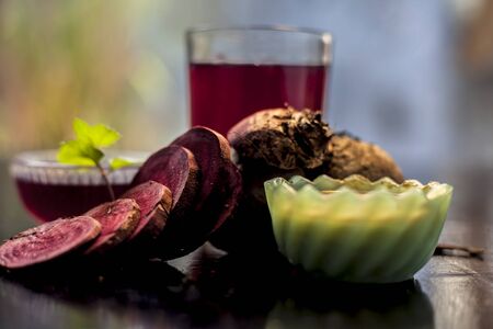 Close up of fresh beetroot juice in a glass along with some Multani mitti or fuller's earth in glass...
