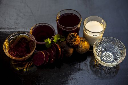 Beetroot face mask on a black glossy surface consisting of some beetroot juice well mixed with milk and honey. Used in a spa for dry skin. Horizontal shot of beetroot face mask on a wooden surface.の写真素材