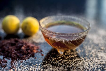 All-purpose ayurvedic salt face mask on the black wooden surface consisting of salt, rock salt, lemon juice, and honey. The face mask as well as a face pack.の写真素材