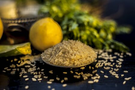 Bunch of coriander leaves, honey, lemon, rice, milk and aloe vera gel face mask for all the skin types and for natural face glow on a black wooden surface. Horizontal shot.の写真素材