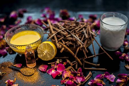 Face mask of manjistha or Indin madder root on a black wooden surface consisting of manjistha roots powder, lemon, milk and some essential rose oil. Face mask used for minor skin infections and acne.の写真素材