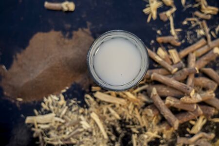 Licorice ayurvedic herb face mask for dark spots on a black wooden board consisting of some licorice...