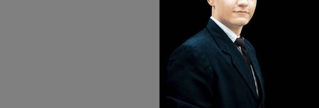 Portrait shot of a confident energetic calm young businessman wearing a blue suit and posing a black background. Shot of businessman with a lot of copy space for advertisement.の写真素材