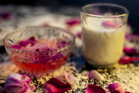 Wheat flour face mask for oily skin on a black colored board consisting of some rose water, milk, wheat flour and raw honey for oily skin. Shot of all the ingredients on the surface with spread flour.の写真素材