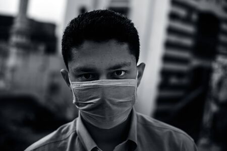 Portrait shot of health-conscious corporate sector man wearing a blue shirt and protecting himself by wearing a Blue colored mask. COVID 19 protection and Coronavirus disease  Prevention.の写真素材