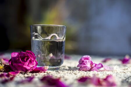 Close up of best face mask DIY mask for natural skin whitening and tan removal on a black colored board consisting of some wheat flour,and water.Shot of a glass of water,spread wheat flour rose petal.の写真素材
