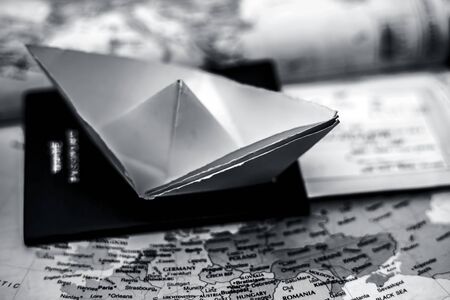Conceptual shot of a paper boat and a passport on European Political map. The concept for planing a European summer vacation trip.の写真素材