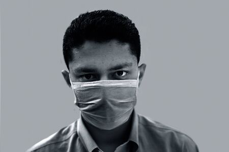 Portrait shot of health-conscious corporate sector man wearing a blue shirt and protecting himself by wearing a Blue colored mask. COVID 19 protection and Coronavirus disease  Prevention isolated.の写真素材