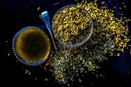 Shot of raw dried Kasuri methi along with its freshly prepared paste in a glass bowl on a black shiny surface.の写真素材