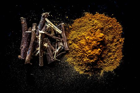 Shot of raw revand chini powder along with its raw root on a wooden surface. Shot in dark gothic...