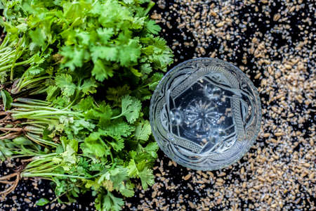 Exfoliating skincare face mask on a black colored surface consisting of some coriander leaves and egg white along with some oats.の写真素材
