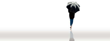 Back view of a lady in a black shirt and blue jeans walking with a black umbrella isolated on white. Shot of lady with black umbrella walking isolated on white.の写真素材