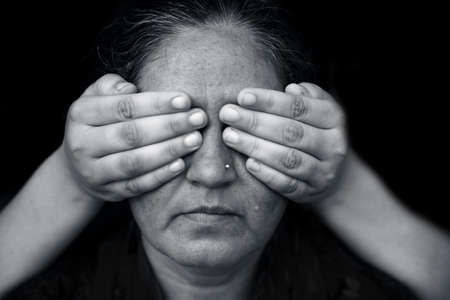 Asian lady covering her eyes.Concept of the three wise monkeys of Gandhi and following the maxim of  Kikazaru, covering his ears, who hears no evil. They are also referred to as three mystic apes.の写真素材