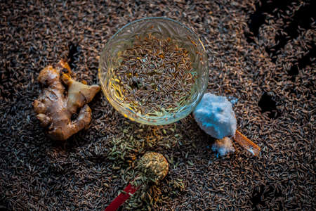 Hair mask for healthy long hair consisting of cumin seeds or zeera or jeera along with some raw egg yolk, water and some olive oil on a brown colored wooden surface.の写真素材