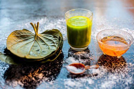 Face mask for preventing acne on a black wooden surface of betel leaves and turmeric powder.の写真素材