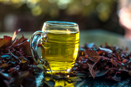 Amaranth leaves juice in a glass mug along with fresh red amaranth leaves with it on a black...
