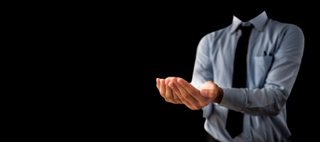 Shot of a unrecognizable man wearing blue shirt black tie and hands in a shape containing something inside it isolated on black background.の写真素材