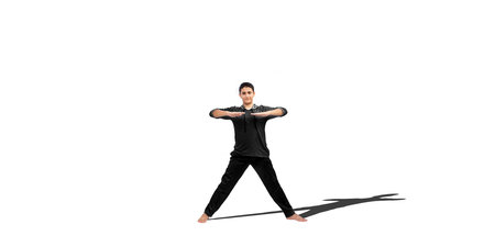Full length shot of a young male teenager doing some exercises isolated on white background.の写真素材