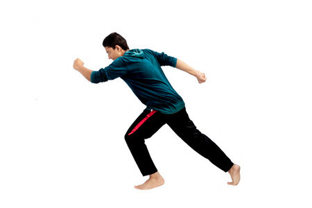 young man practicing tai chi isolated on white background in full lengthの写真素材