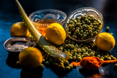 Green pea face mask for glowing and radiant skin consisting of some green peas, honey, yogurt, turmeric, lemons, and aloe vera gel on black background.の写真素材