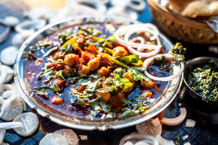 Full breakfast plate on the black surface. Indian Delhi style Chole bhature along with some onion rings and pudhina/mint chutney on a black surface.の写真素材
